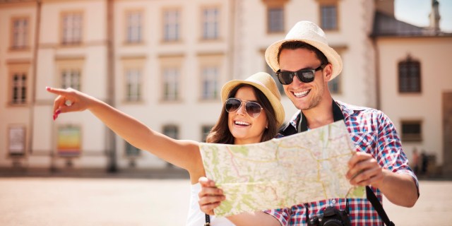Happy tourist sightseeing city with map from The Huffington Post